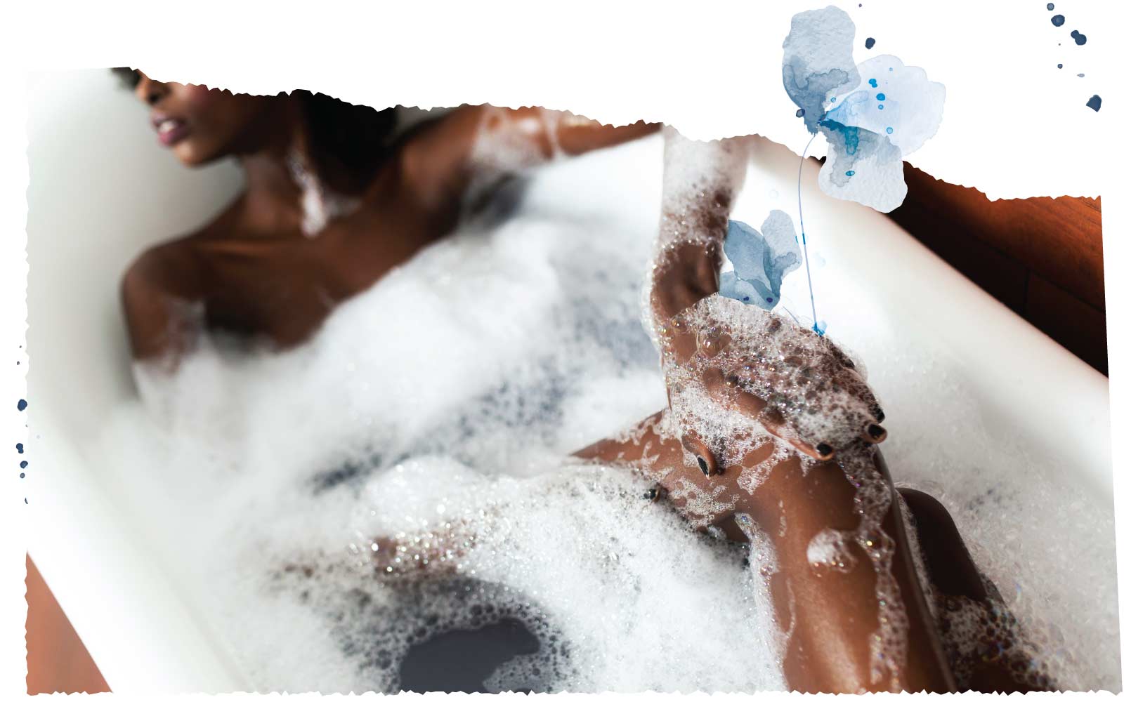 Person in bath tub covered in bubbles with blue flower decorative frame