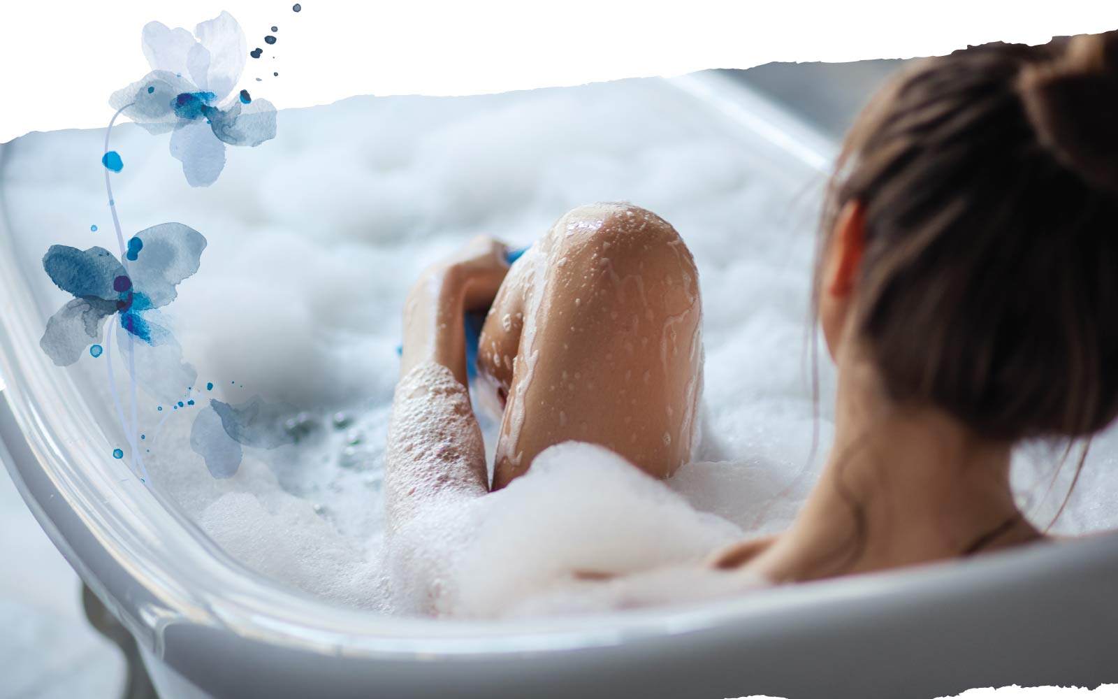Person in bath tub covered in bubbles with blue flower decorative frame