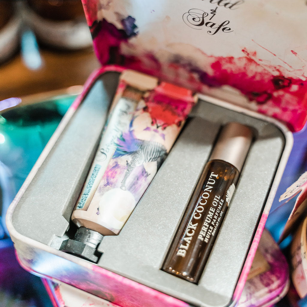 Barefoot Venus Black Coconut perfect pair products perfume oil and hand cream displayed in container.