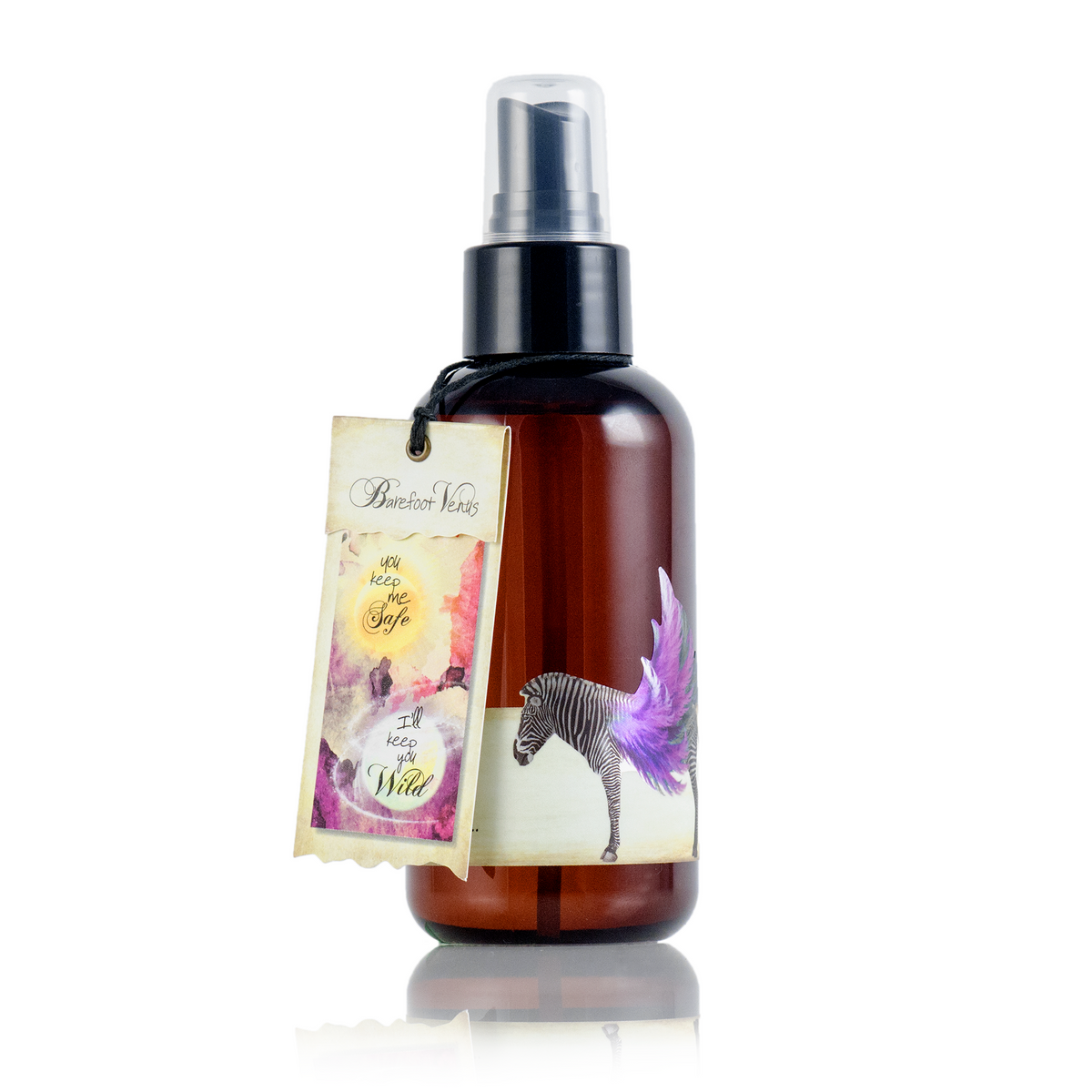 A dark brown bottle with a spray dispenser of Barefoot Venus Black Coconut Argan body oil and a floral zebra design.