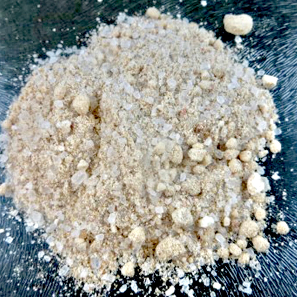 A pile of Barefoot Venus bath soak on a dark surface.