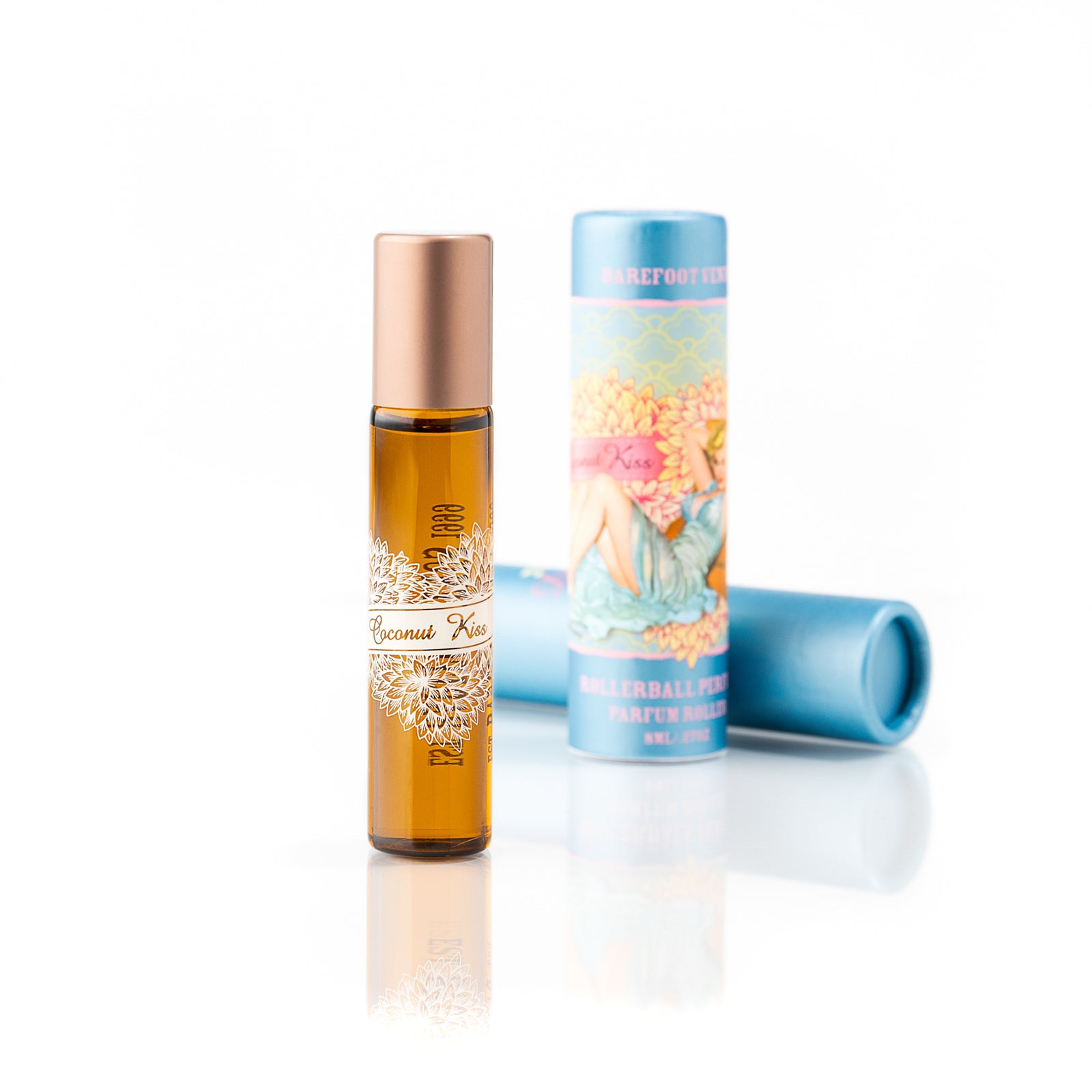 Person holding Barefoot Venus Coconut Kiss perfume oil with a woman in a blue dress and a flower background design being held by a woman in a blue dress.