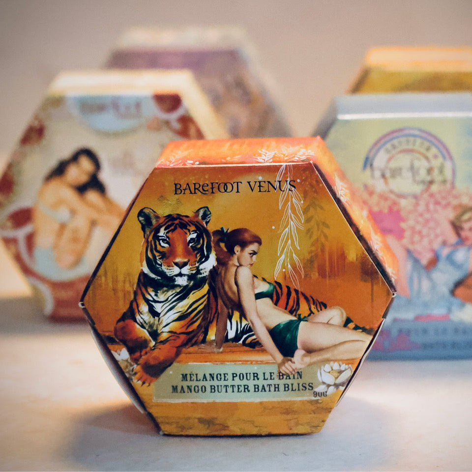 A collection of Barefoot Venus bath bliss in assorted scents, with packaging featuring illustrations of women and nature.