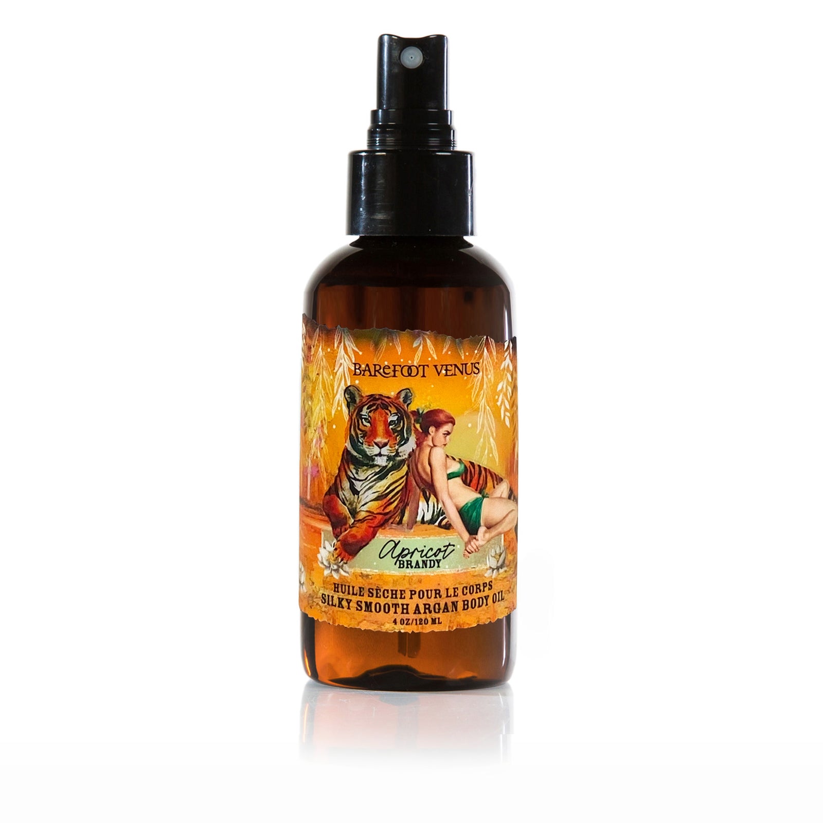 A spray bottle of Barefoot Venus Apricot Brandy Argan body oil with a black lid and a design of a tiger and a woman in a green outfit on a white background.