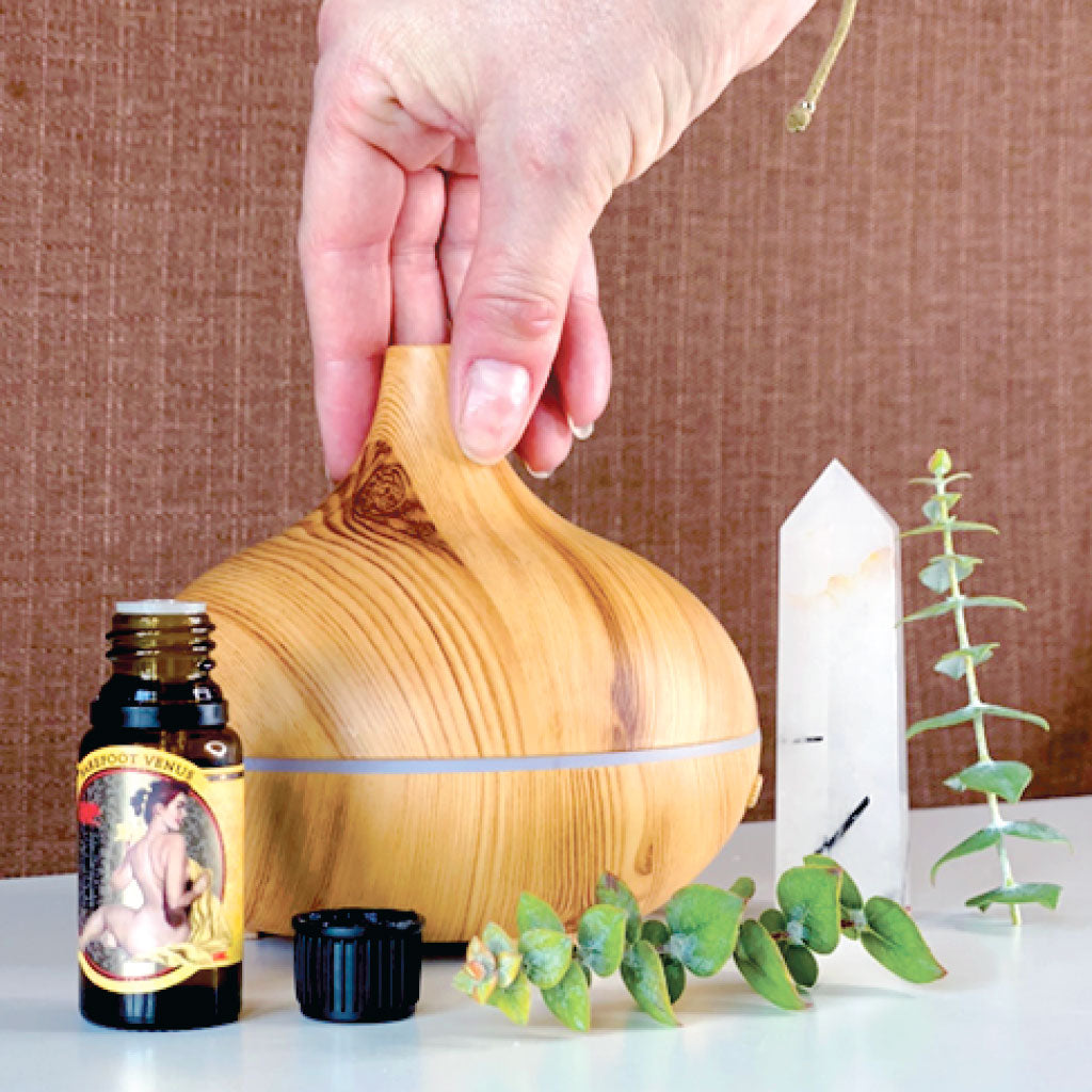 Barefoot Venus Essential Oil beside a diffuser and crystal