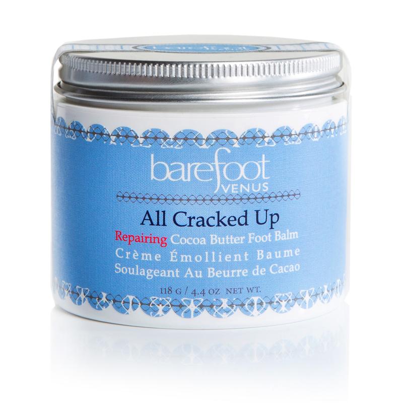 Person using Barefoot Venus All Cracked Up foot balm with blurred background.