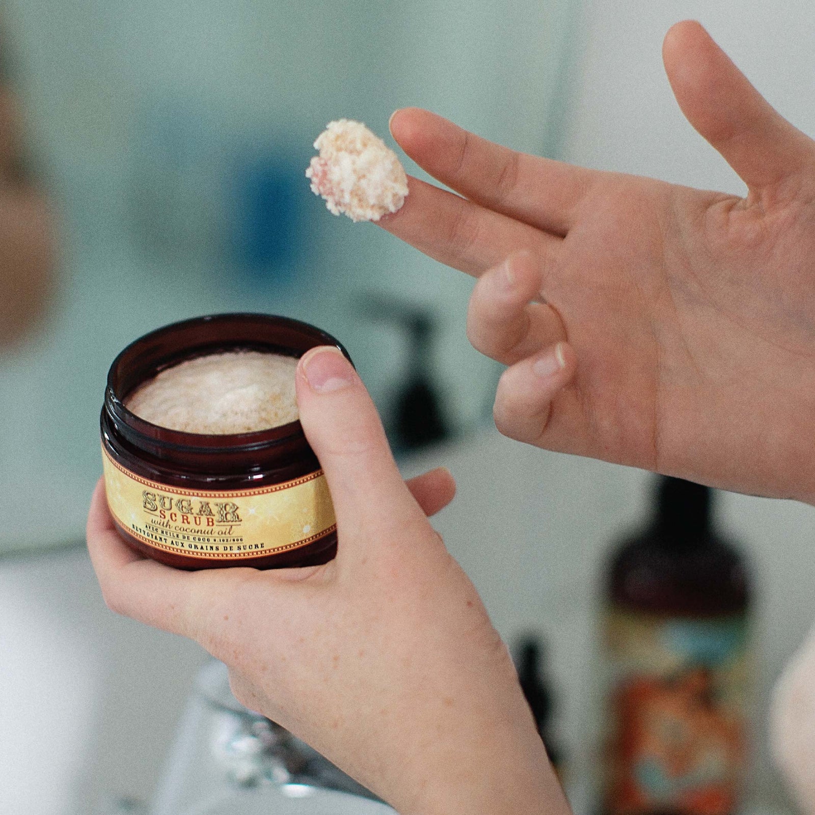 Container of Barefoot Venus Ginger Snap sugar scrub product featuring a woman in a red outfit lying in a toboggan design on a white background.